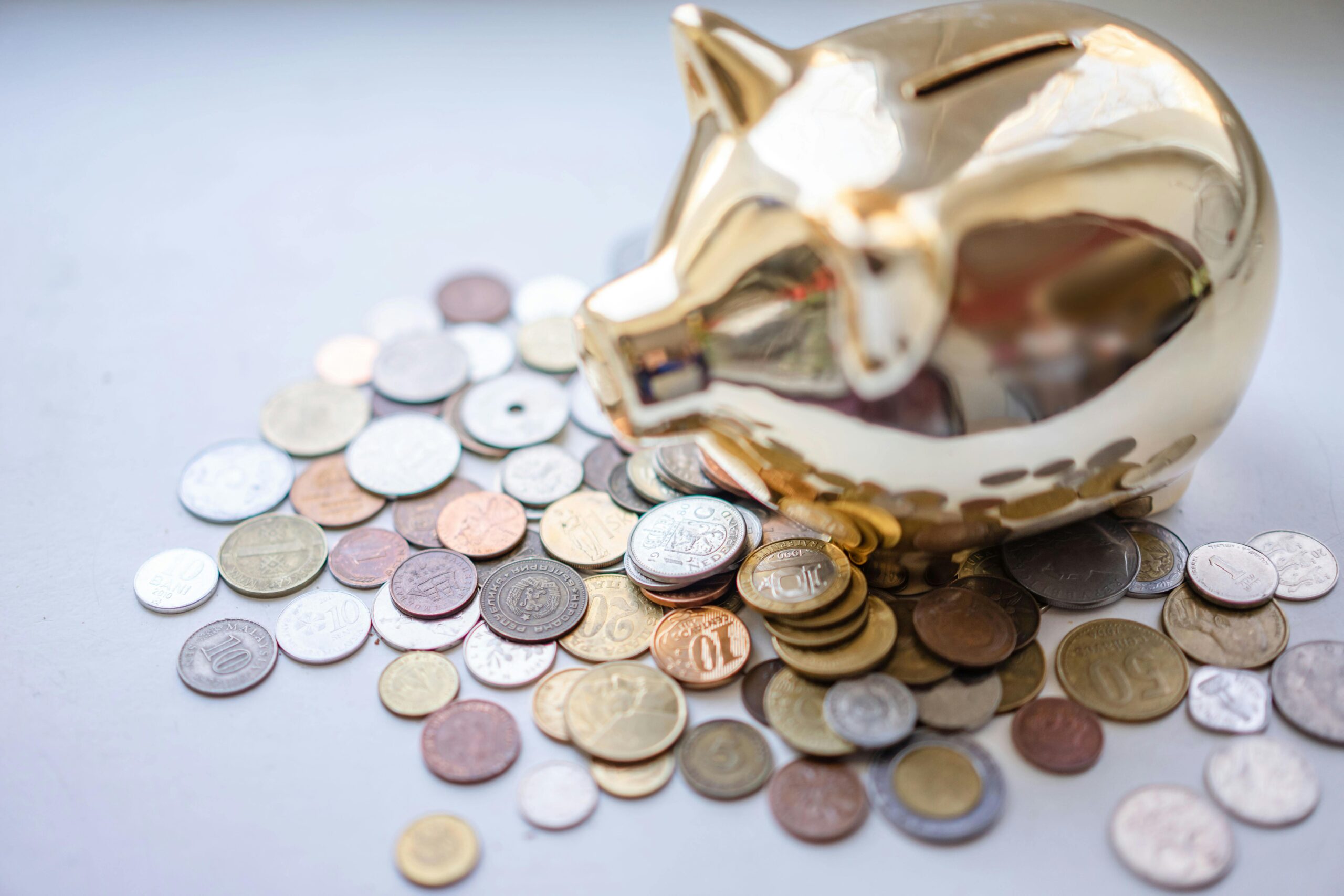 A golden piggy bank surrounded by assorted coins, symbolizing savings and wealth.