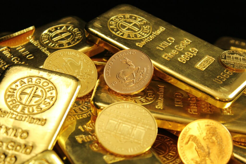A detailed image of gold bars and coins symbolizing wealth and financial investment. Invest in Gold Now?