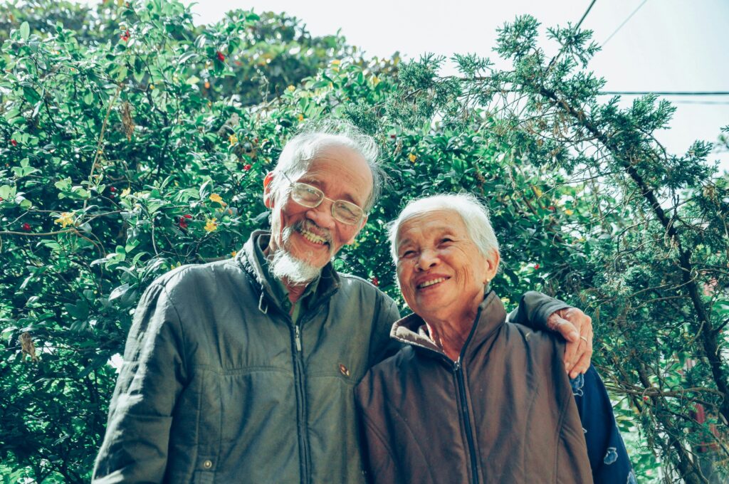 Senior couple enjoying a joyful moment together in a lush garden setting, exuding love and happiness. Fire Movement